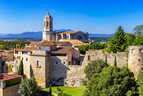 Tramo de la Muralla de Gerona con una iglesia al fondo