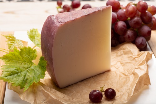 Cuña de queso con un racimo de uvas
