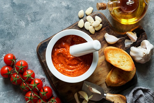 Mortero de cocina con aceite, pan, ajo y tomate